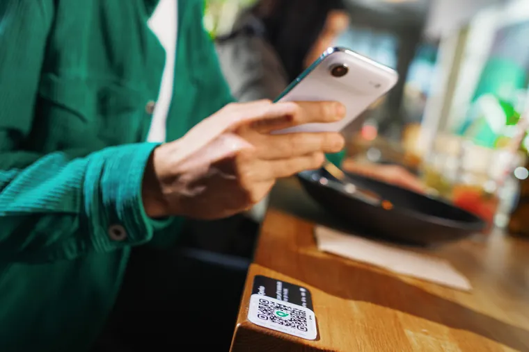 Host platí u stolu telefonem přes QR kód nalepený na desce stolu